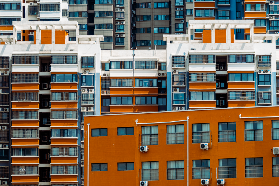 Imagem de prédios residenciais em uma área urbana, destacando a arquitetura e diversidade de janelas e cores.