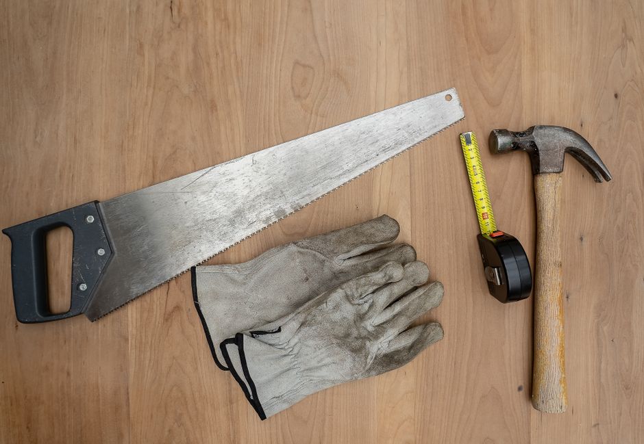 Imagem de ferramentas de carpintaria dispostas sobre uma superfície de madeira, simbolizando trabalho manual e bricolagem.
