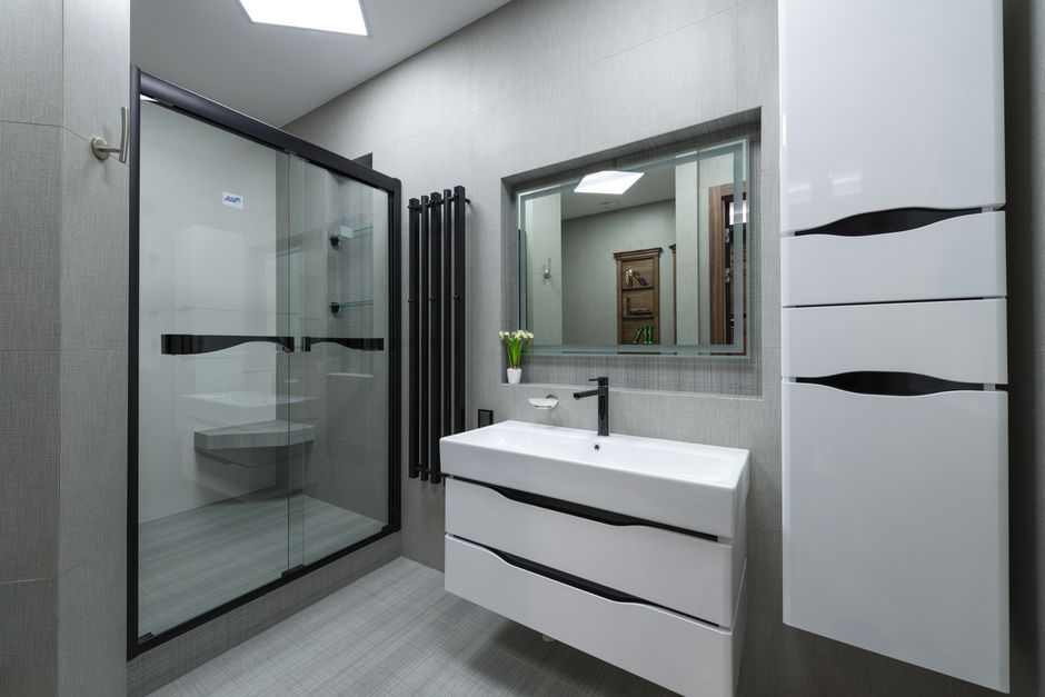 Banheiro moderno com espelho grande, pia suspendedora e móveis de design minimalista, criando um ambiente clean e funcional.