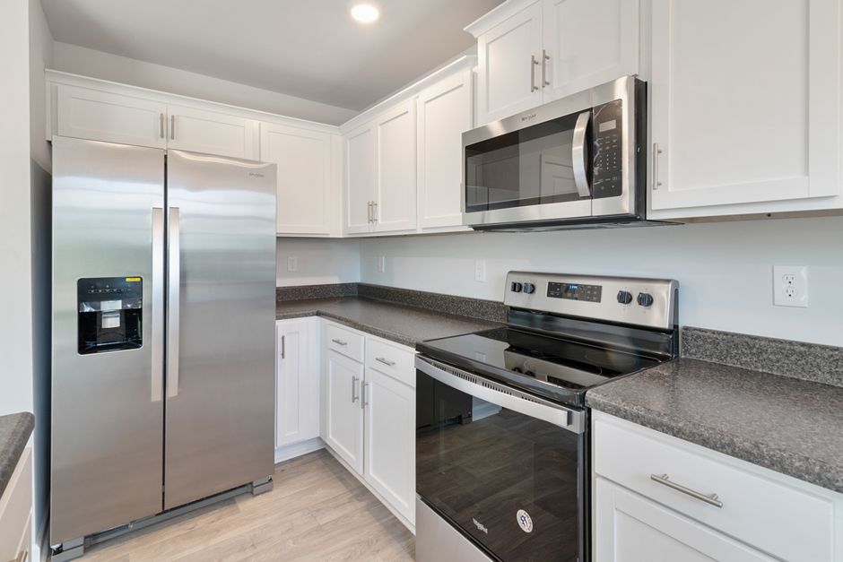 Cozinha moderna com eletrodomésticos de aço inox na configuração de um espaço funcional e bem-organizado.