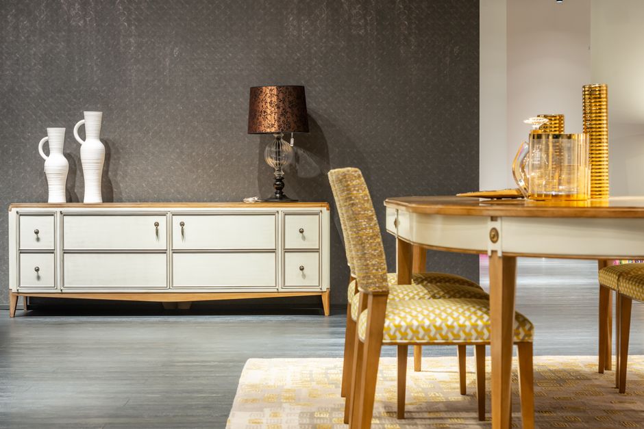 Salão de jantar elegante com móveis vintage, luminária de mesa e decoração sofisticada, ideal para artigos sobre decoração de interiores ou design de ambientes residenciais.