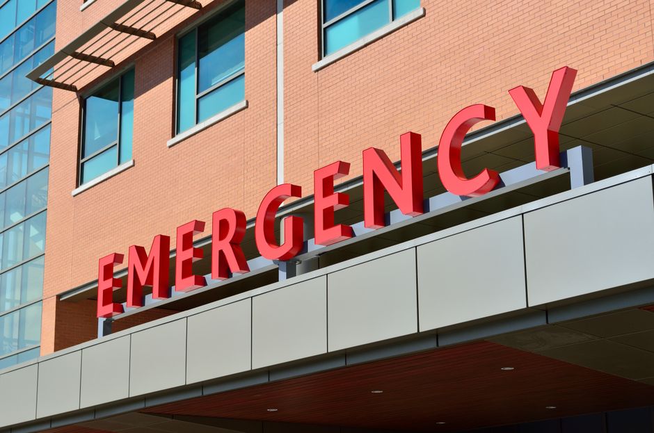 Imagem de um prédio de hospital com destaque para a sinalização de emergência, simbolizando cuidados médicos e atendimento de urgência.