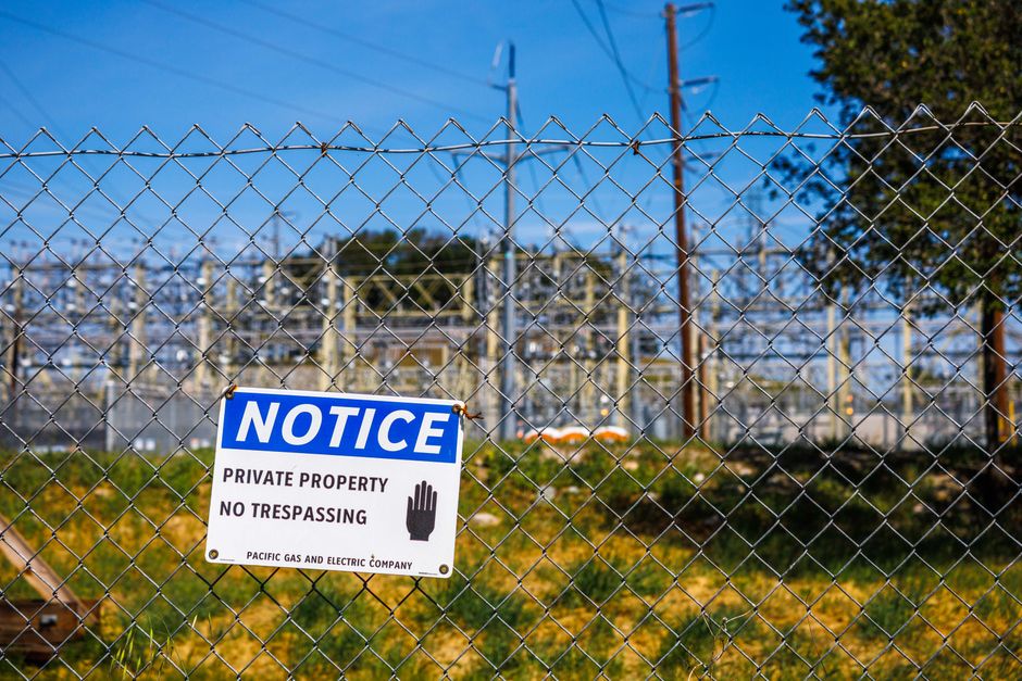 Imagem de uma cerca de arame com placa de aviso de propriedade privada, simbolizando restrição e segurança em áreas industriais ou instalações elétricas.