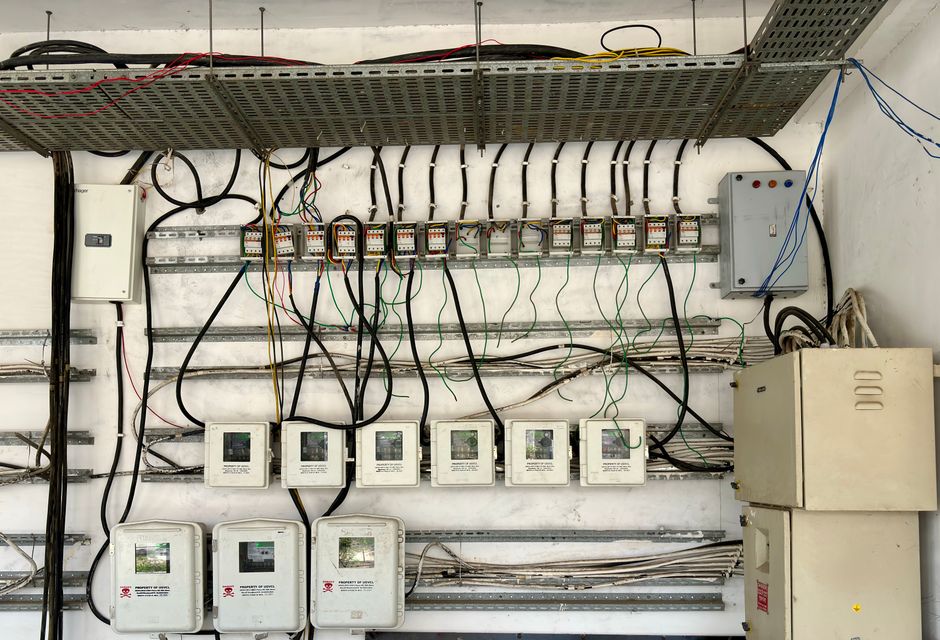 Infraestrutura elétrica industrial com disjuntores, medidores e cabeamento organizado em um ambiente técnico de automação ou controle.