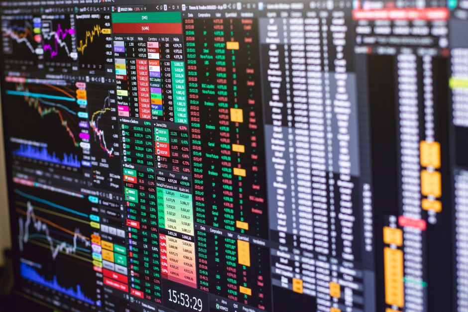 Monitor exibindo gráficos e dados financeiros, utilizado para análise de investimentos e mercado de ações.