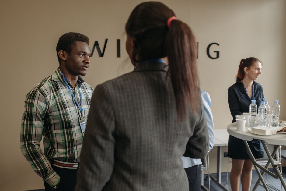 Pessoas em uma reunião de negócios ou networking, destacando a interação profissional em um ambiente corporativo.