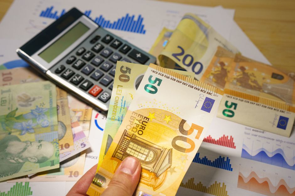 Imagem de análise financeira com notas de euro, gráficos de desempenho e calculadora, ilustrando planejamento e gestão financeira.