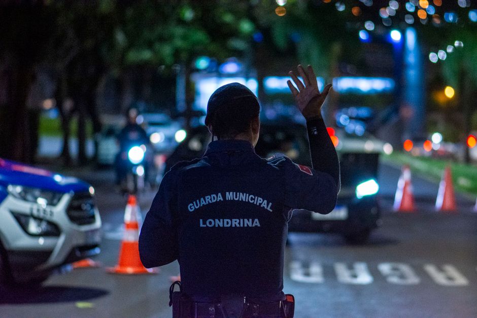 Autoridade municipal realizando controle no trânsito durante a noite em uma área urbana.