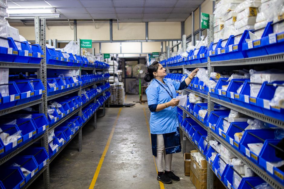 Profissional realizando inventário ou controle de estoque em armazenamento de produtos hospitalares ou farmacêuticos.
