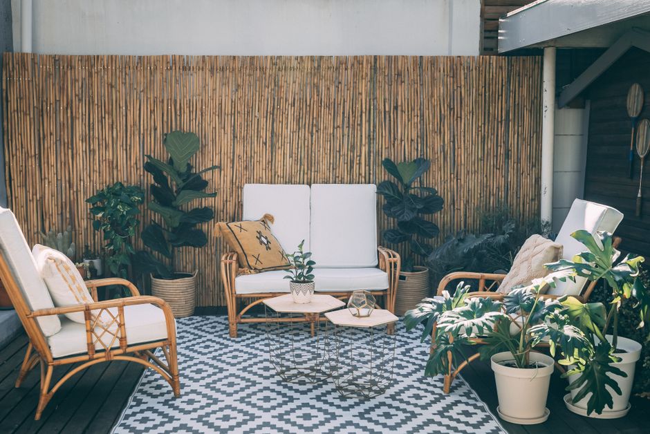 Espaço ao ar livre decorado com móveis de madeira e plantas, ideal para momentos de descanso e convivência ao ar livre.