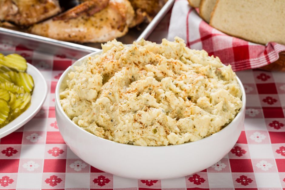 Imagem de uma tigela de purê de batatas cremoso com uma pitada de páprica, ideal para ilustrar receitas caseiras ou refeições familiares.