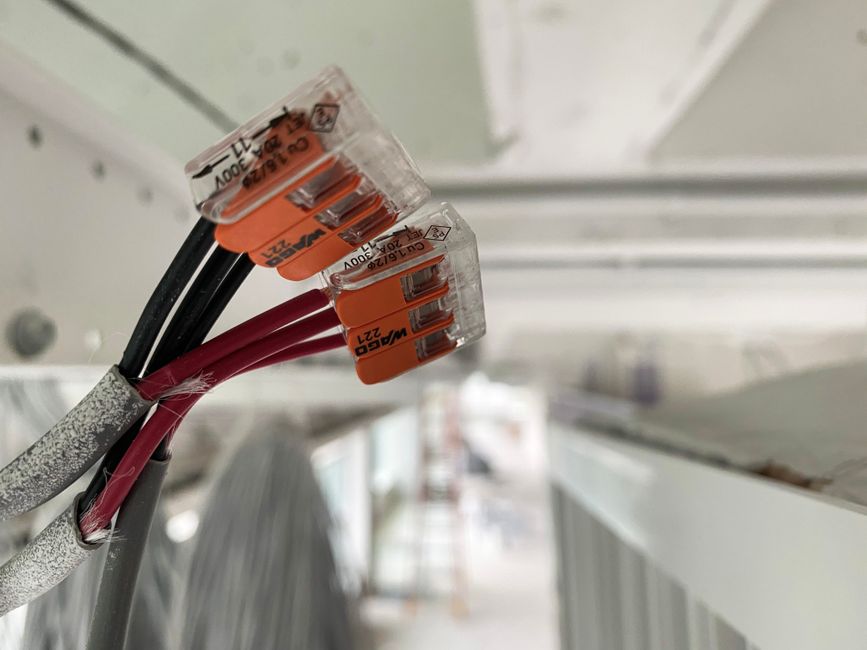 Imagem de cabos elétricos com conectores de identificação, simbolizando infraestrutura elétrica e instalação técnica.