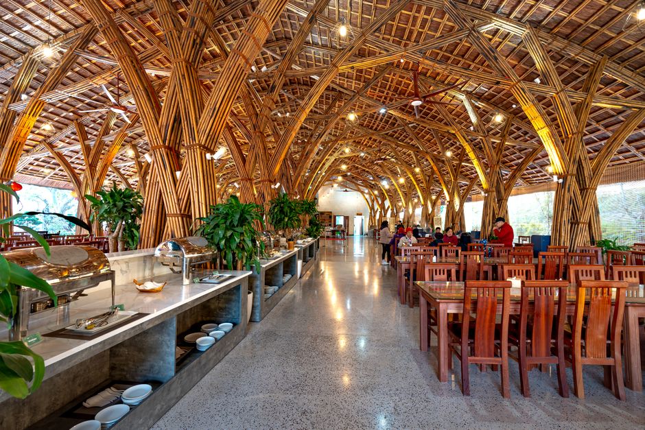 Interior de restaurante com estrutura de madeira rústica, ambiente acolhedor e clientes apreciando a comida.