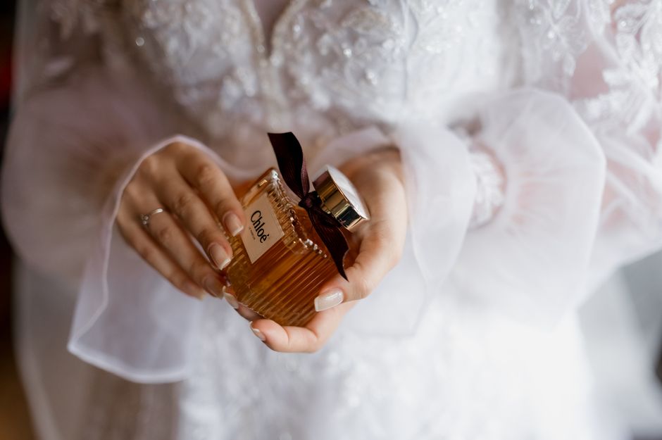 Pessoa segurando uma garrafa de perfume Chanel, destacando elegância e luxo para um artigo sobre cuidados pessoais ou moda.