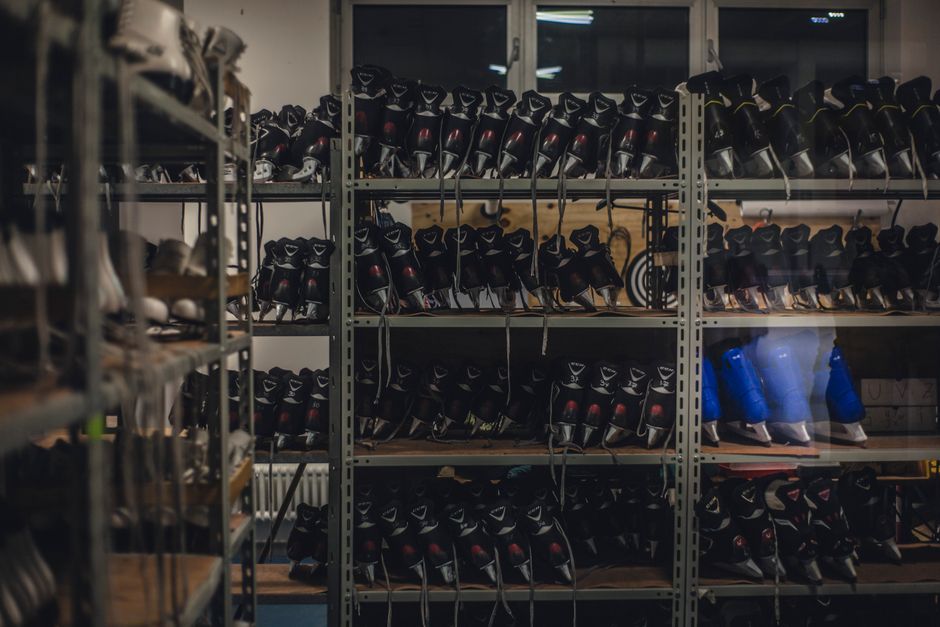 Estante organizando equipamentos de hóquei no gelo, sugerindo preparo para jogos ou treinos esportivos.