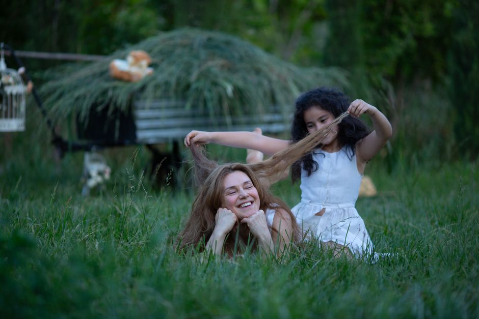 Duas meninas brincando em um ambiente ao ar livre, demonstrando diversão e conexão com a natureza.