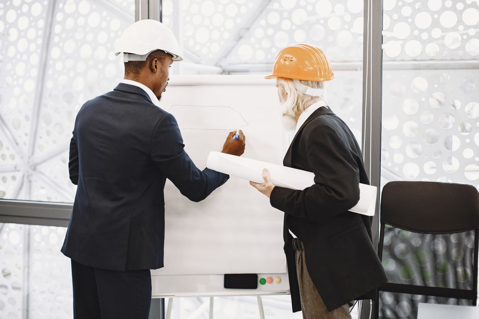 Profissionais de engenharia discutindo projetos em um ambiente de escritório futurista para elaboração de planos de construção.