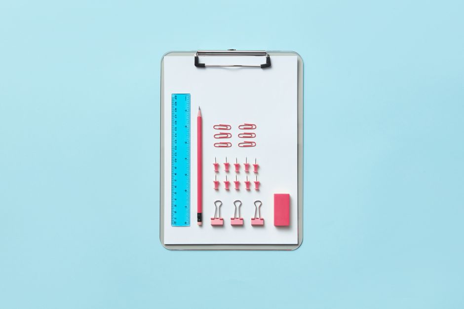Imagem de materiais de escritório organizados em uma prancheta, ideal para ilustrar temas relacionados à organização e planejamento escolar ou profissional.