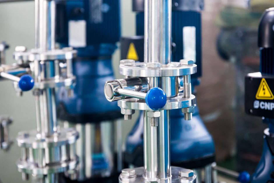 Imagem de equipamentos industriais de precisão em um ambiente de fábrica ou laboratório, destacando tecnologia e inovação na produção.