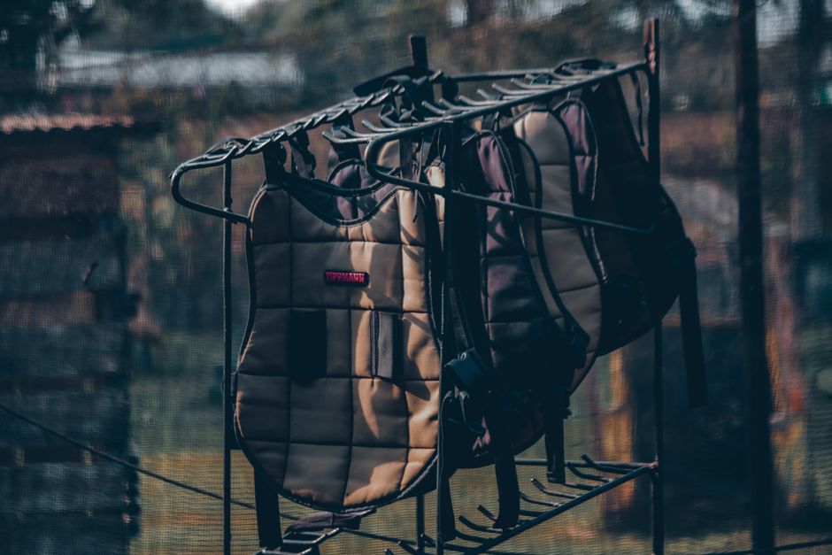 Imagem de roupas penduradas em um varal ao ar livre em um ambiente residencial, capturada ao entardecer ou ao amanhecer, com foco na rotina doméstica e organização do lar.
