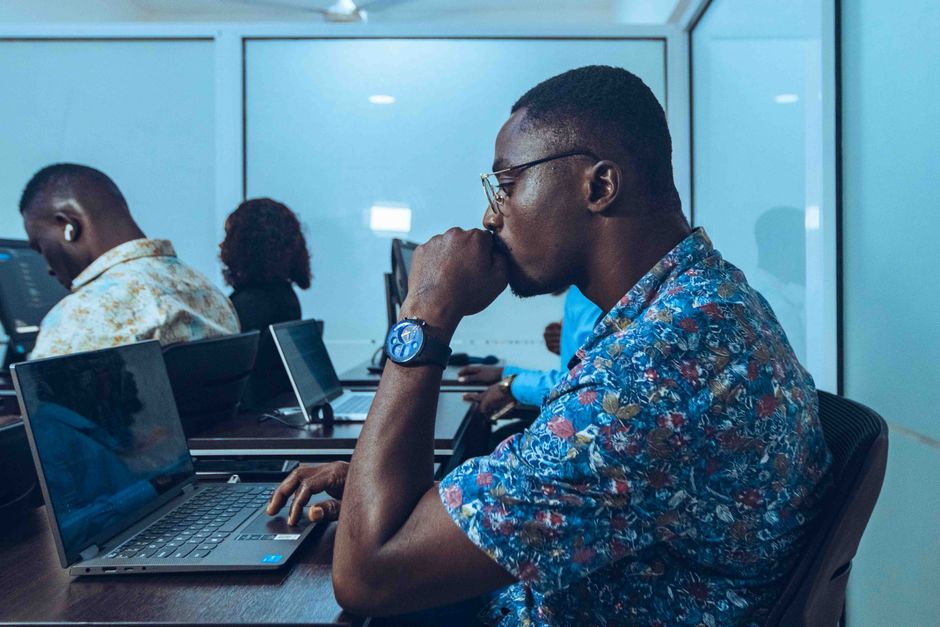 Pessoa concentrada em ambiente de trabalho, pensando ou analisando informações em um escritório moderno.