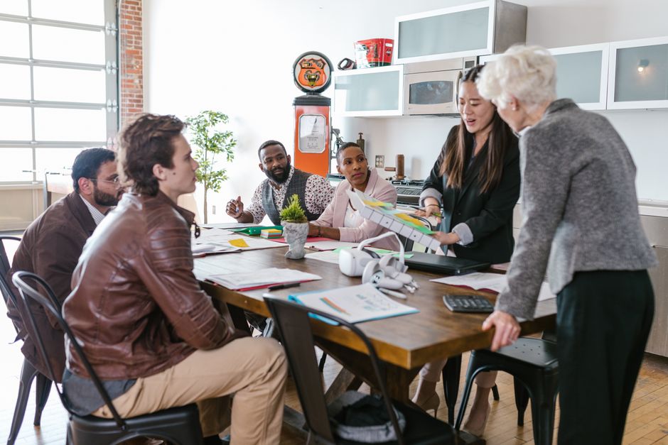 Reunião de equipe em ambiente de trabalho colaborativo, discutindo estratégias de gestão e planejamento empresarial.