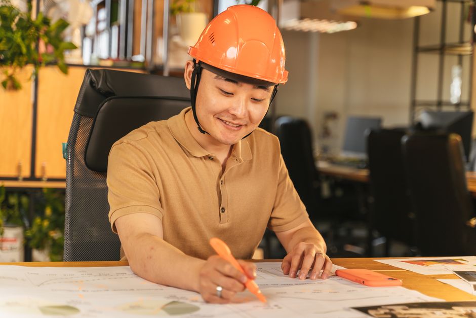 Profissional de engenharia analisando projetos em um ambiente de escritório com foco em técnicas de construção e planejamento estratégico.