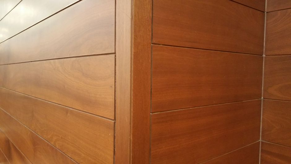 Foto de uma parede de madeira com acabamento liso, destacando a textura e tonalidade natural da superfície, ideal para ilustrar decoração ou arquitetura de interiores.