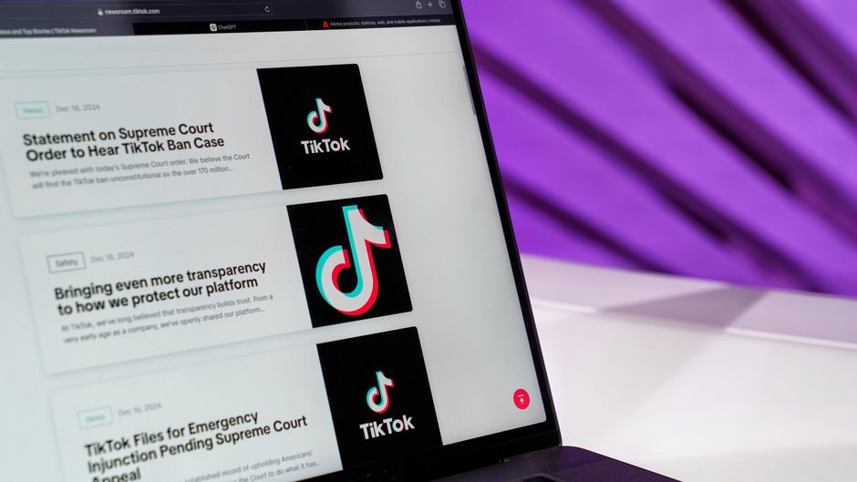 Imagem de uma tela de computador exibindo notícias relacionadas ao TikTok e à Suprema Corte, com fundo roxo refletido na tela, sugerindo um tema de mídia digital e notícias jurídicas.