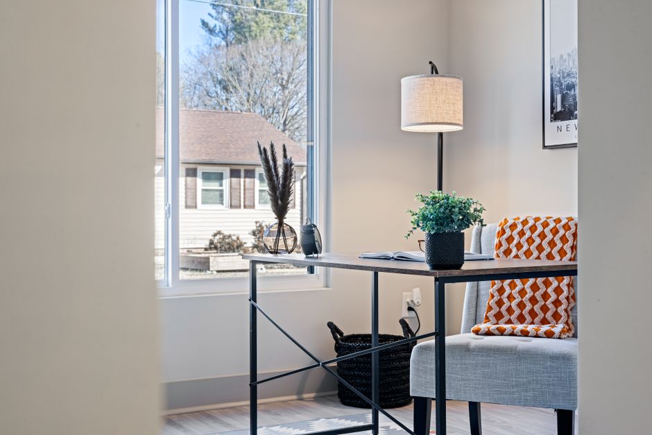 Um espaço de trabalho acolhedor e bem iluminado, ideal para trabalho remoto ou estudos, com detalhes de decoração moderna e funcionalidade.