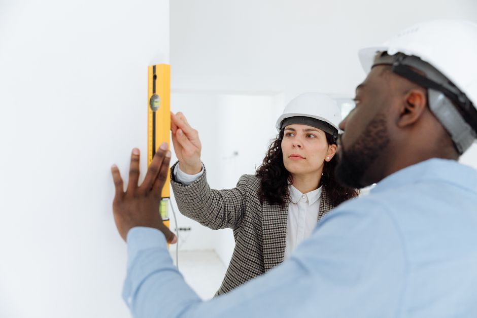 Dupla de profissionais de engenharia realizando inspeção em obra interior, reforçando a importância do planejamento técnico na construção civil.