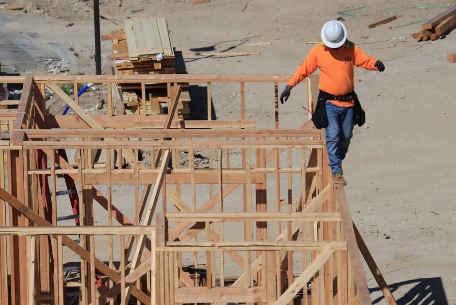 Profissional de construção civil analisando a estrutura de uma edificação em fase de montagem em um canteiro de obras.