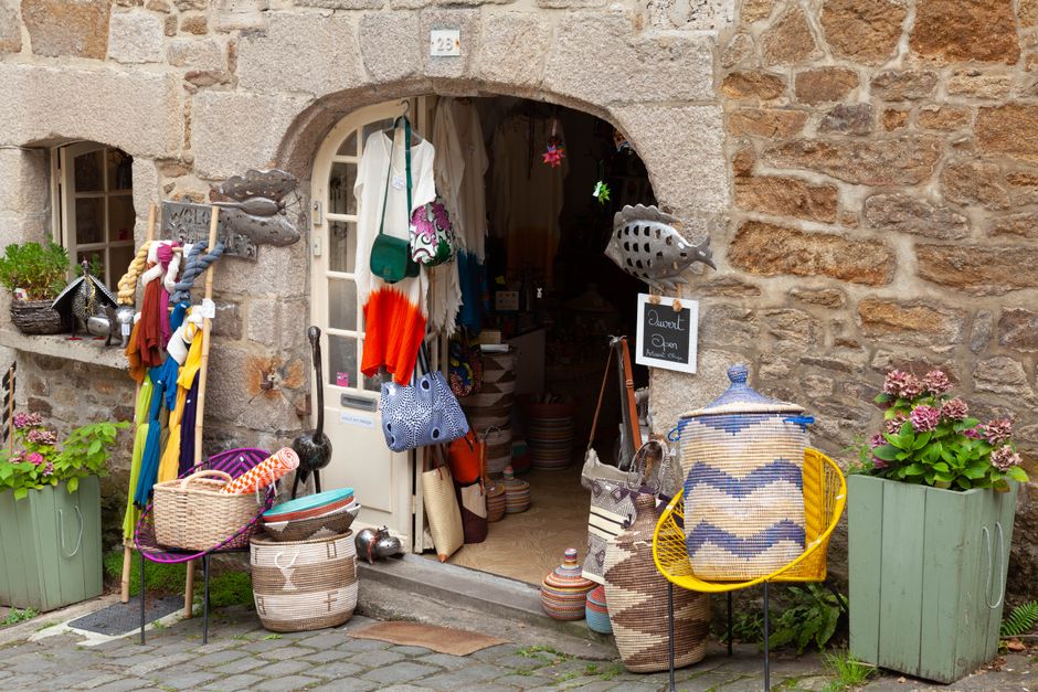 Imagem de uma loja de artesanato com estilo rústico, exibindo objetos decorativos e acessórios coloridos na entrada.