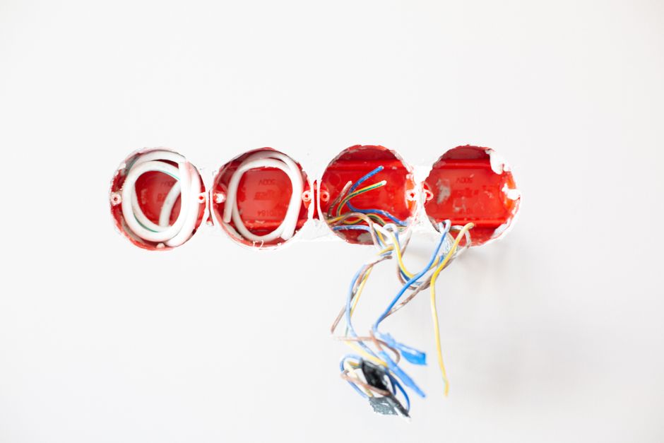 Imagem de uma instalação elétrica com fios expostos e caixas de controle, simbolizando manutenção ou instalações elétricas residenciais ou comerciais.