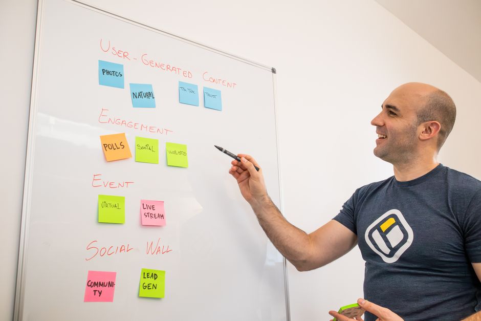 Homem apresentando estratégia de marketing digital em quadro branco durante reunião de equipe