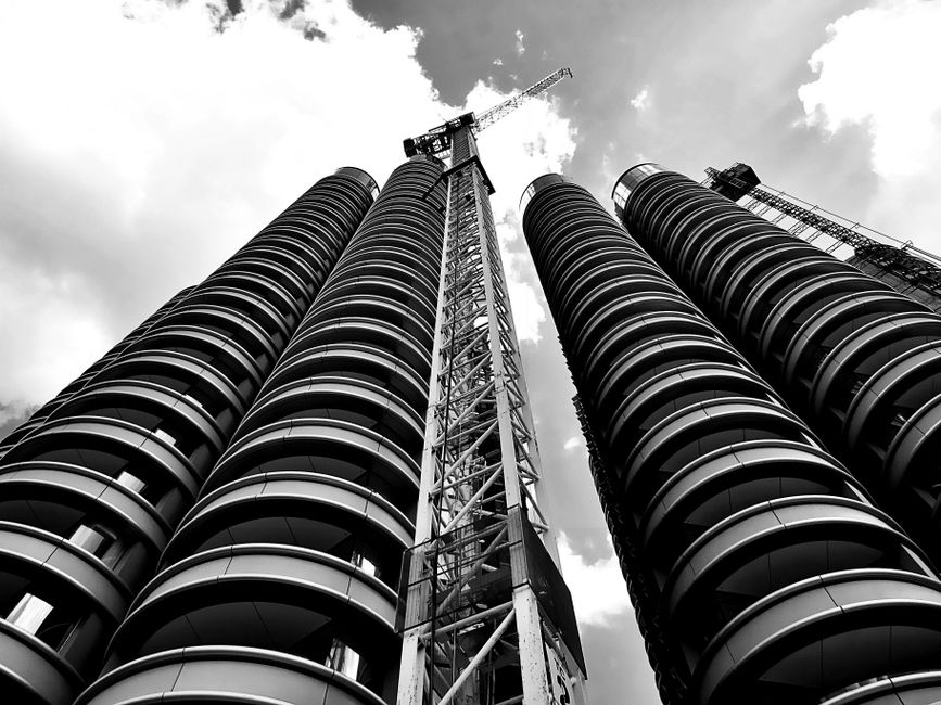 Imagem de torres de edifícios modernos em construção, destacando a infraestrutura urbana e o avanço da engenharia civil.