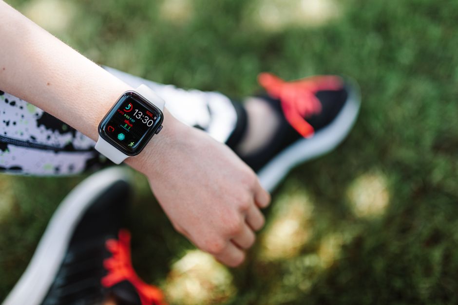 Pessoa verificando sua frequência cardíaca após uma sessão de corrida ao ar livre, destacando o tema de saúde e fitness ao vivo.