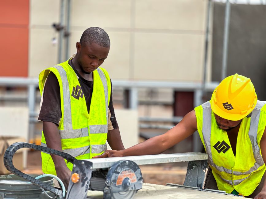 Homens engenheiros analisando um projeto de construção em uma obra em andamento.