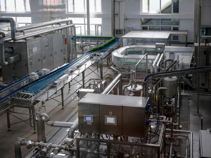 Imagem de uma instalação industrial moderna com equipamentos de processamento e transporte de líquidos ou produtos, enfatizando inovação tecnológica na fabricação.