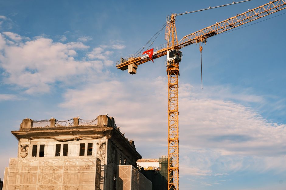 Imagem de um edifício em reforma com uma grua de construção ao fundo, representando progresso e desenvolvimento urbano.