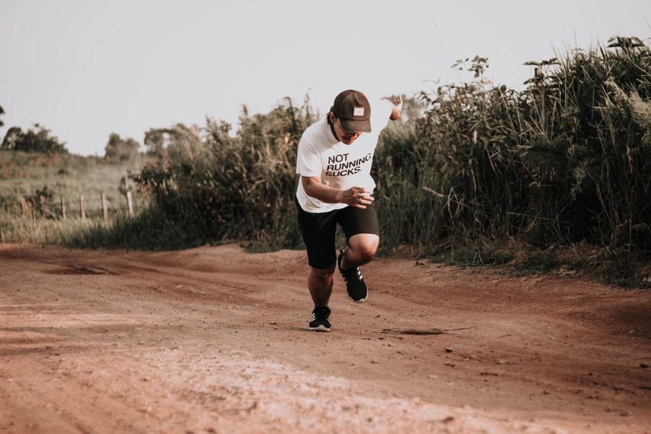 Pessoa caminhando ao ar livre em um caminho de terra, transmitindo uma sensação de aventura e conexão com a natureza.