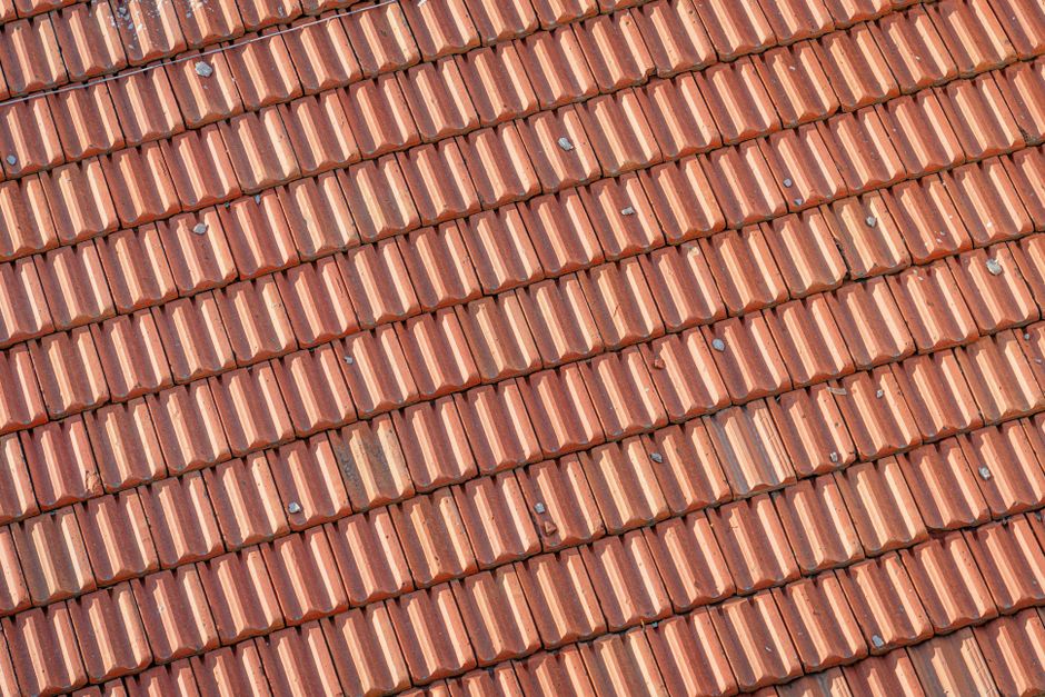Imagem de telhado com telhas de barro, mostrando detalhes e padronização da cobertura residencial.