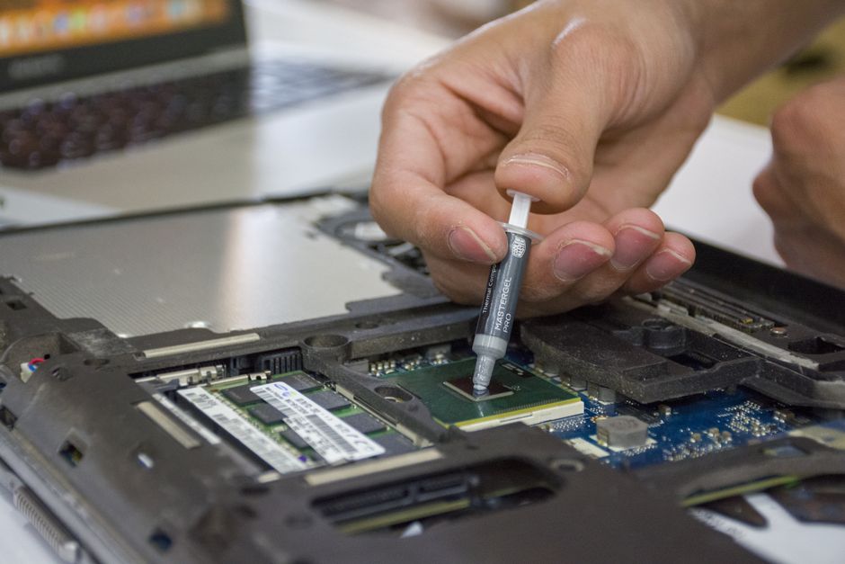 Profissional realizando atualização de componentes internos de um notebook, ilustrando manutenção tecnológica.