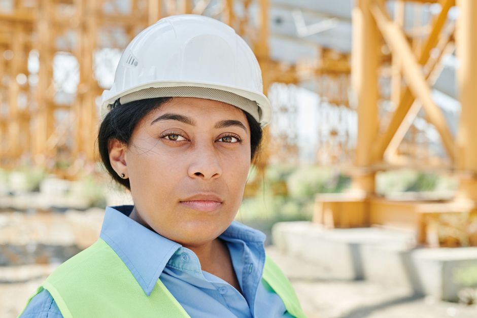 Mulher engenheira em canteiro de obras, simbolizando liderança e supervisão na construção civil.