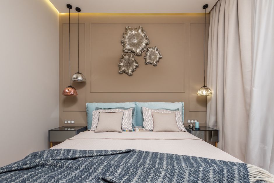 Quarto moderno com decoração elegante, iluminação suave e detalhes decorativos na parede, ideal para inspiração de design de interiores para hospedagem ou residências sofisticadas.