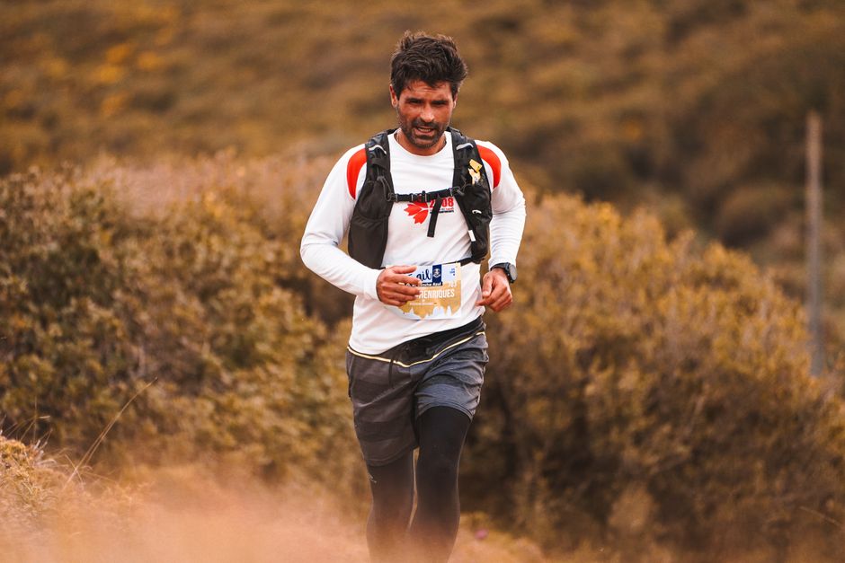 Homem participando de uma corrida de outdoor em um ambiente natural durante o dia.