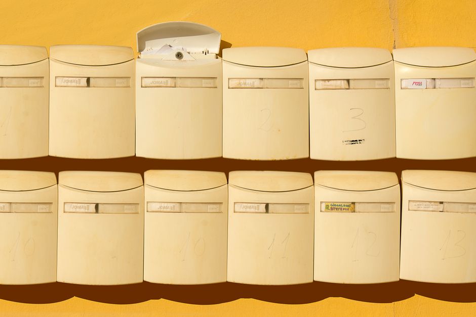 Arquivo de caixas de correspondência em uma área comum, representando organização e comunicação.