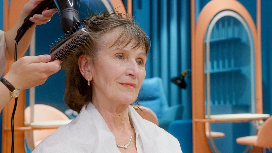 Mulher fazendo cabelo em um salão de beleza, representando cuidados pessoais e estética feminina.