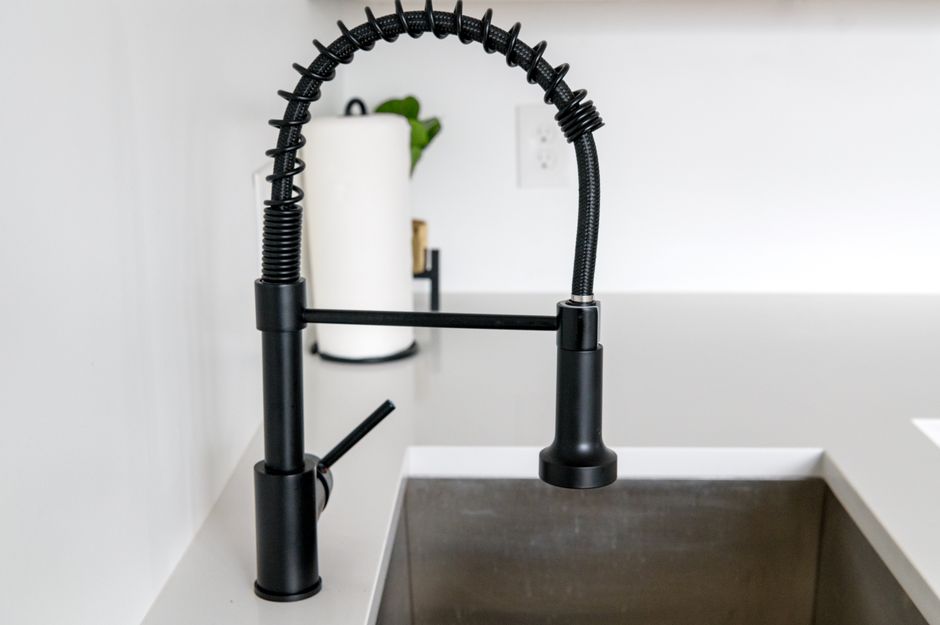 Cafusa de cozinha moderna instalada em uma bancada de mármore, com fundo de parede branca e detalhes decorativos.