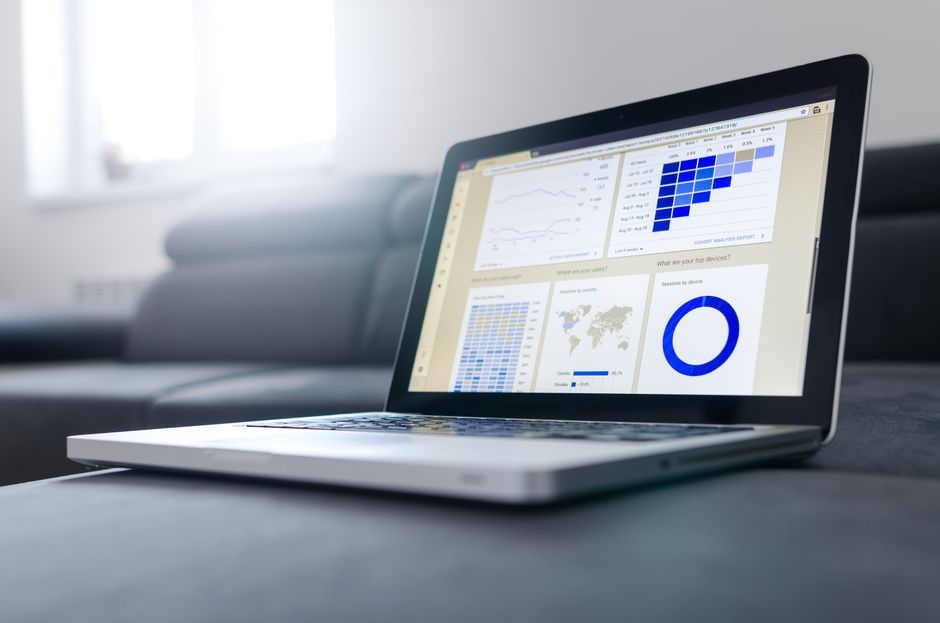Imagem de um laptop exibindo gráficos e dados analíticos, representando análise de dados e tomada de decisões empresariais.